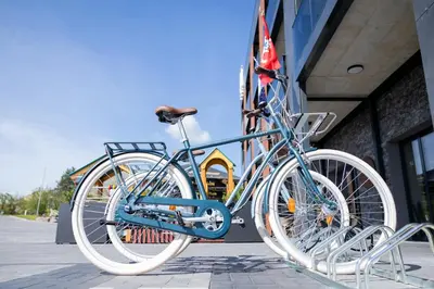 a bike is chained to the side of a building at Molėtai Hotel in Molėtai