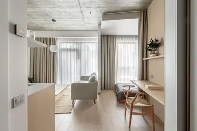 a kitchen and living room with a table and a chair at Cozy Japanese Oasis with Balcony, Gramophone, Netflix in Vilnius