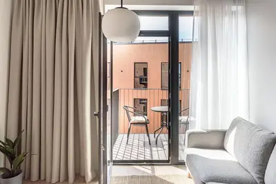 a living room with a couch and a chair at Cozy Japanese Oasis with Balcony, Gramophone, Netflix in Vilnius