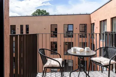 a patio with a table and chairs on a balcony at Cozy Japanese Oasis with Balcony, Gramophone, Netflix in Vilnius
