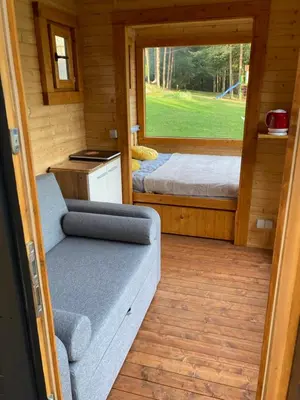 a room with a couch and a bed and a window at Našio kempingas in Antanaše