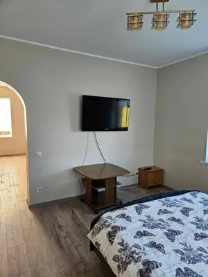 a bedroom with a bed and a tv on the wall at Red Brick House in Naciūnai