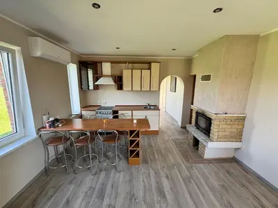 a kitchen with a table and chairs and a fireplace at Red Brick House in Naciūnai