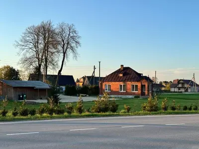 a house sitting on the side of a road at Red Brick House in Naciūnai