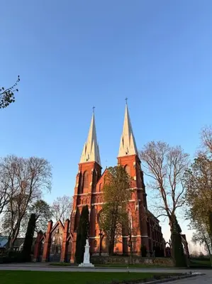 an old church with two towers on top of it at Red Brick House in Naciūnai