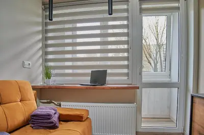a room with a window with a laptop on a table at COZY VISIT, Studio4 with balcony, 24h Self Chek-in, on the first floor in Kaunas