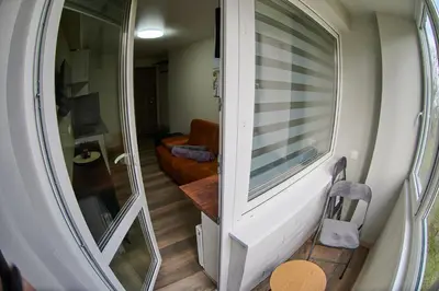 a room with a sliding glass door and a couch at COZY VISIT, Studio4 with balcony, 24h Self Chek-in, on the first floor in Kaunas