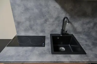 a kitchen counter with a black sink and a sink at COZY VISIT, Studio4 with balcony, 24h Self Chek-in, on the first floor in Kaunas