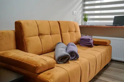 a brown couch with towels on top of it at COZY VISIT, Studio4 with balcony, 24h Self Chek-in, on the first floor in Kaunas