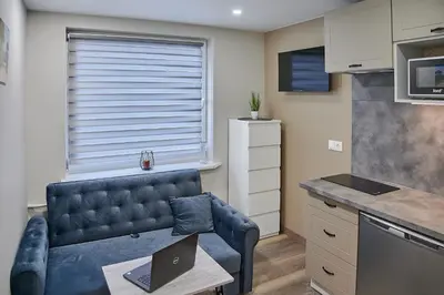 a living room with a couch and a laptop on a table at Great location STUDIO1 on the first floor, 24h self check-in in Kaunas