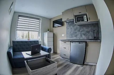 a kitchen with a couch and a table with a laptop at Great location STUDIO1 on the first floor, 24h self check-in in Kaunas
