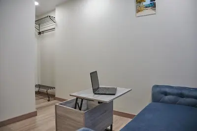 a laptop on a table in a room with a couch at Great location STUDIO1 on the first floor, 24h self check-in in Kaunas