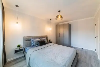 a bedroom with a large bed in a room at Grey Apartments in Šiauliai