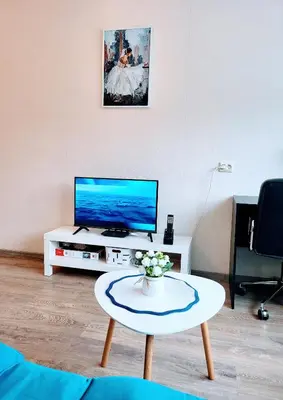 a living room with a tv and a coffee table at COZY Apartment in the SUN CITY in Šiauliai