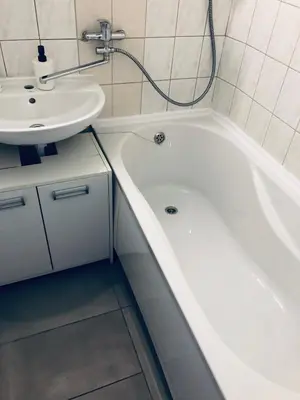 a bathroom with a white tub and a sink at COZY Apartment in the SUN CITY in Šiauliai