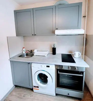 a kitchen with a washing machine and a sink at COZY Apartment in the SUN CITY in Šiauliai