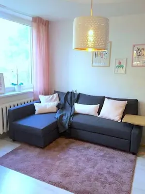 a blue couch in a living room with a window at ☆ Perfect Spot Apartment ☆ everywhere in 10 min. in Vilnius
