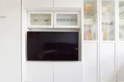 a white cabinet with a tv inside of it at Hidden gem apartment In 10min everywhere in Vilnius