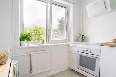 a kitchen with white cabinets and a window at Hidden gem apartment In 10min everywhere in Vilnius