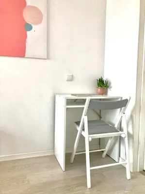 a desk with a chair next to a table with a plant at Hidden gem apartment In 10min everywhere in Vilnius
