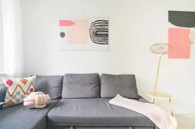 a grey couch in a living room with a lamp at Hidden gem apartment In 10min everywhere in Vilnius
