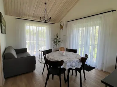 a living room with a table and chairs and a couch at Žalčio guolis in Lekėčiai