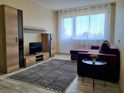 a living room with a couch and a tv at TILZES 24 APARTMENTS - self check in in Šiauliai