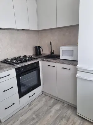 a kitchen with white cabinets and a stove top oven at TILZES 24 APARTMENTS - self check in in Šiauliai