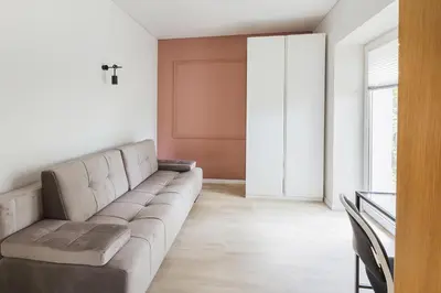 a living room with a couch and a window at Observation Deck Apartments in Kaunas