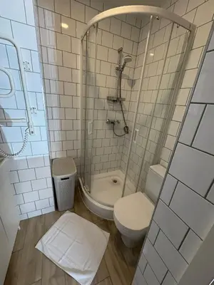 a small bathroom with a toilet and a shower at Observation Deck Apartments in Kaunas