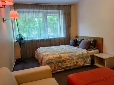 a hotel room with a bed and a window at 3 rooms apartment with balcony in Kaunas