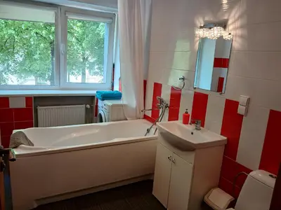 a bathroom with a white tub and a sink at 3 rooms apartment with balcony in Kaunas