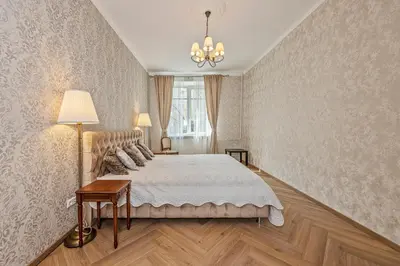a bedroom with a large bed and a chandelier at Riverside apartment in Vilnius