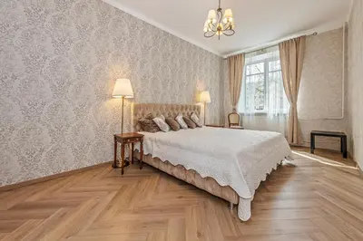 a bedroom with a large bed and a chandelier at Riverside apartment in Vilnius