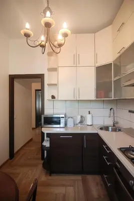 a kitchen with white cabinets and a microwave at Riverside apartment in Vilnius