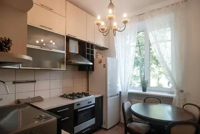 a kitchen with a table and a small kitchen with a table and a window at Riverside apartment in Vilnius