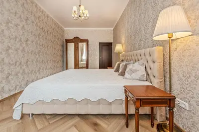 a bedroom with a white bed and a table at Riverside apartment in Vilnius