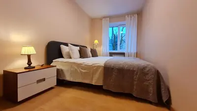 a bedroom with a bed with a dresser and a window at Rehouse, Vilniaus 45 in Vilnius