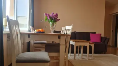a living room with a table with a vase of flowers at Rehouse, Vilniaus 45 in Vilnius