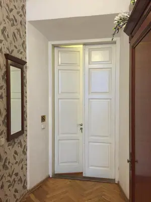 a white door in a room with a mirror at Florens guesthouse in Vilnius