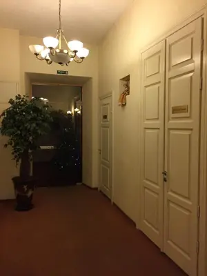 a hallway with a door and a potted plant at Florens guesthouse in Vilnius