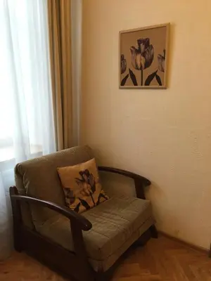 a chair in a room with a picture on the wall at Florens guesthouse in Vilnius