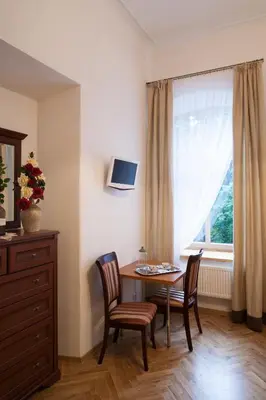 a dining room with a table and chairs and a window at Florens guesthouse in Vilnius