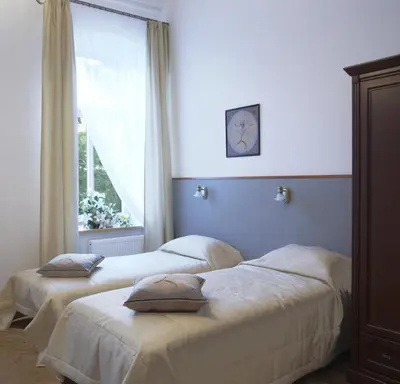 two beds in a room with a window at Florens guesthouse in Vilnius