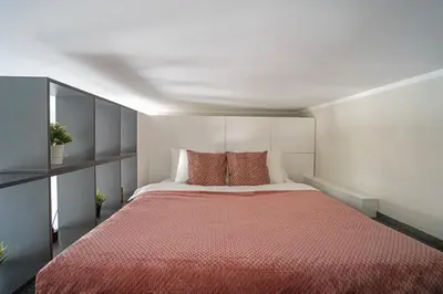 a bedroom with a large bed with a red blanket at Cozy Loft next to Main Station in Kaunas