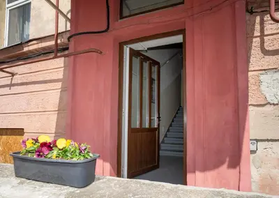 a red building with a pot of flowers in front of a door at Cozy Loft next to Main Station in Kaunas