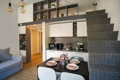 a kitchen with a table and chairs in a room at Cozy Loft next to Main Station in Kaunas