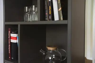 a glass jar on a shelf with books at Cozy Loft next to Main Station in Kaunas