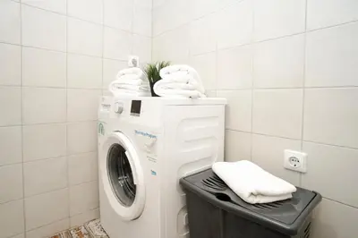 a washing machine with towels on top of it at Cozy Loft next to Main Station in Kaunas