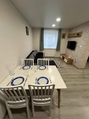 a white table with chairs and a living room at Svečių namelis in Kaunas
